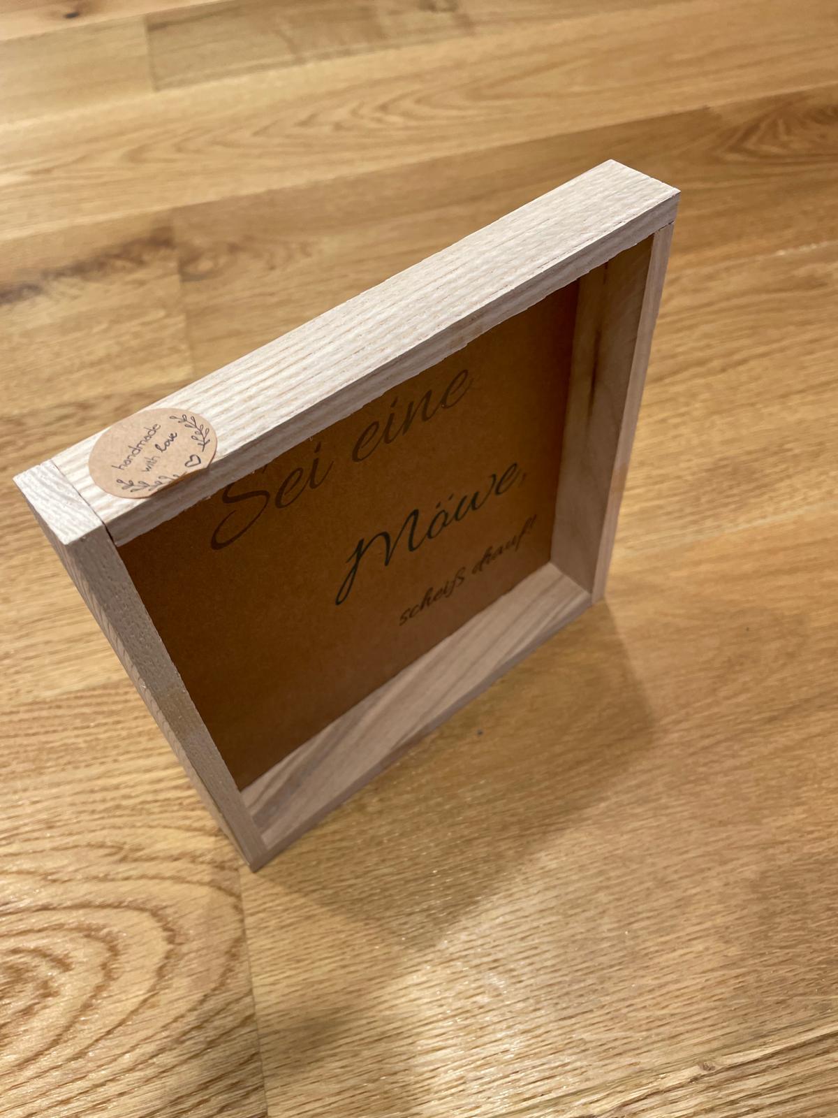 Klötzchen Spruch auf DesignPapier im Holzsticks Rahmen "Sei eine Möwe, sch*** drauf!"